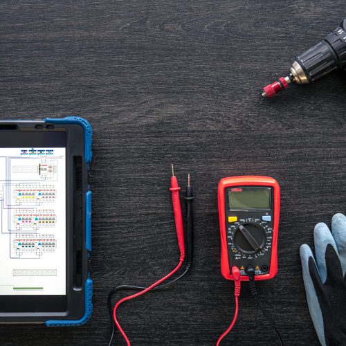 Composition with digital tablet and electrician work items, top view.